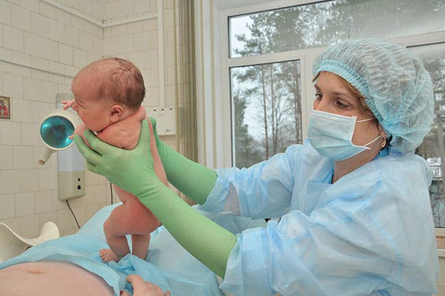 nurse holding a new born baby
